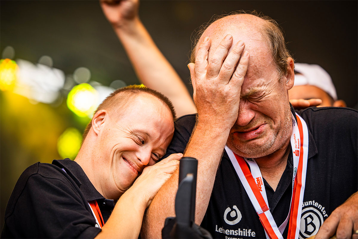 Zwei Boccia-Teamkollegen liegen sich in den Armen.