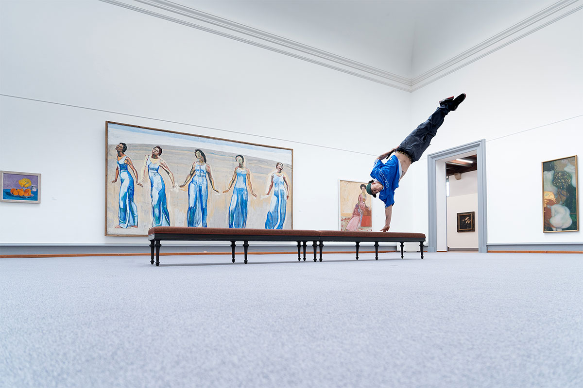 Das Foto zeigt die einzigartige Kombination zweier Kunstformen durch einen Athleten: urbaner Breakdance trifft auf Kunstgemälde in einem Museum.